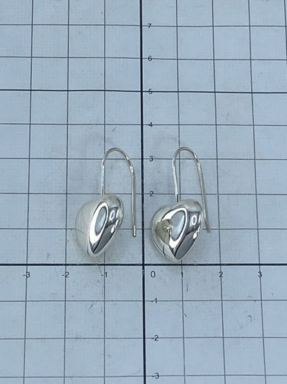 Aretes en gancho de plata sobre fondo azul mostrando el brillo del cartoneado