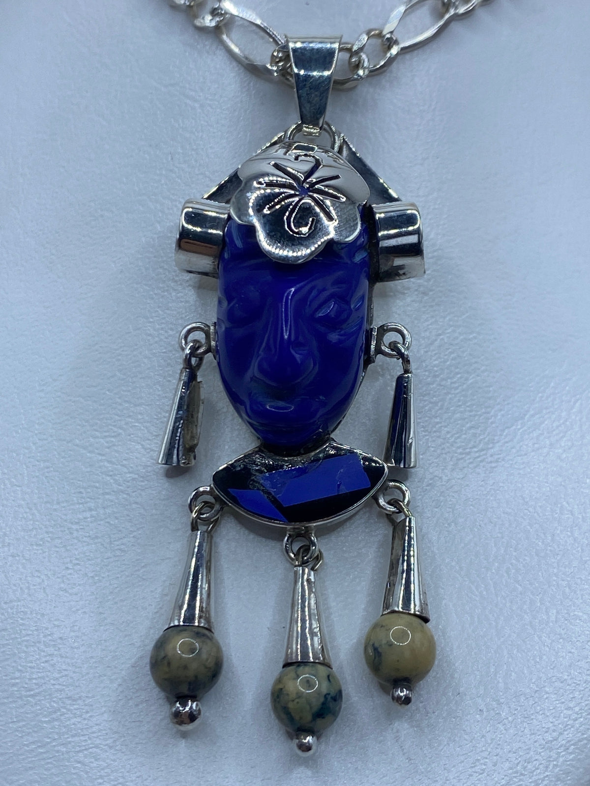 Dije de plata repujado con lapislázuli azul, perfil de K'inich Janaab' Pakal en relieve profundo