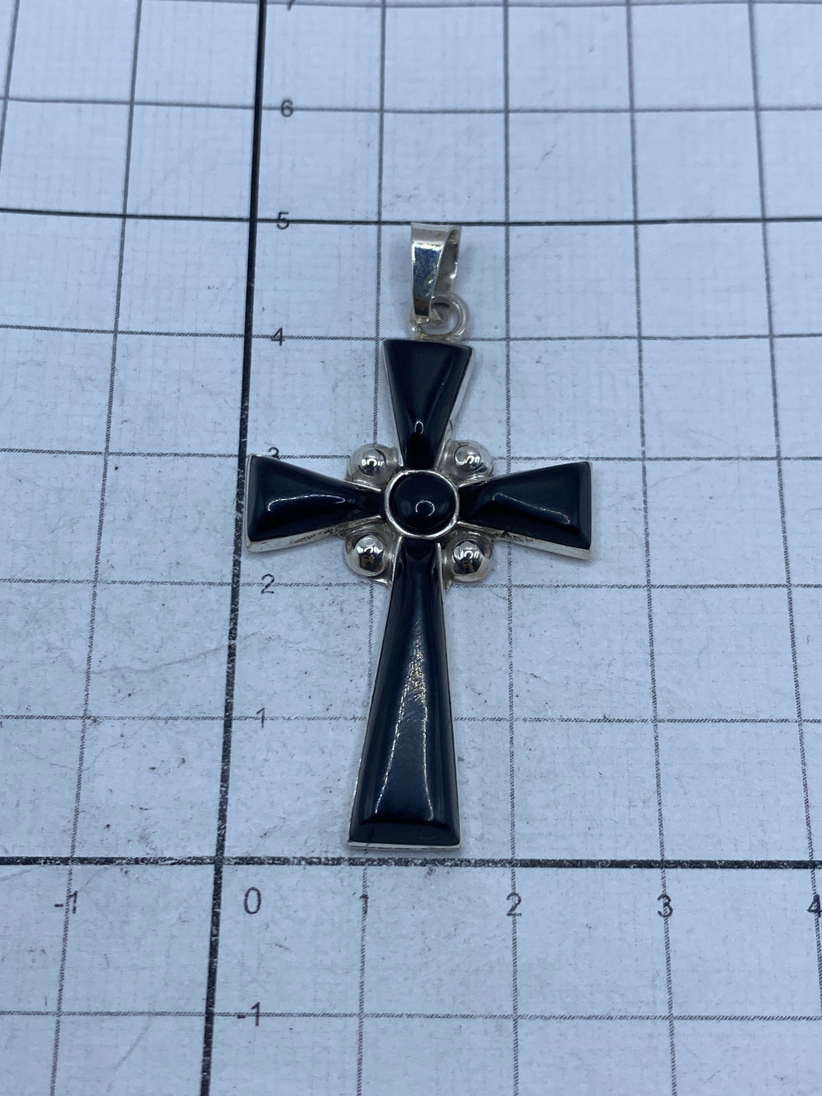Cruz sobre fondo blanco con regla de medición mostrando largo de 4.8 cm