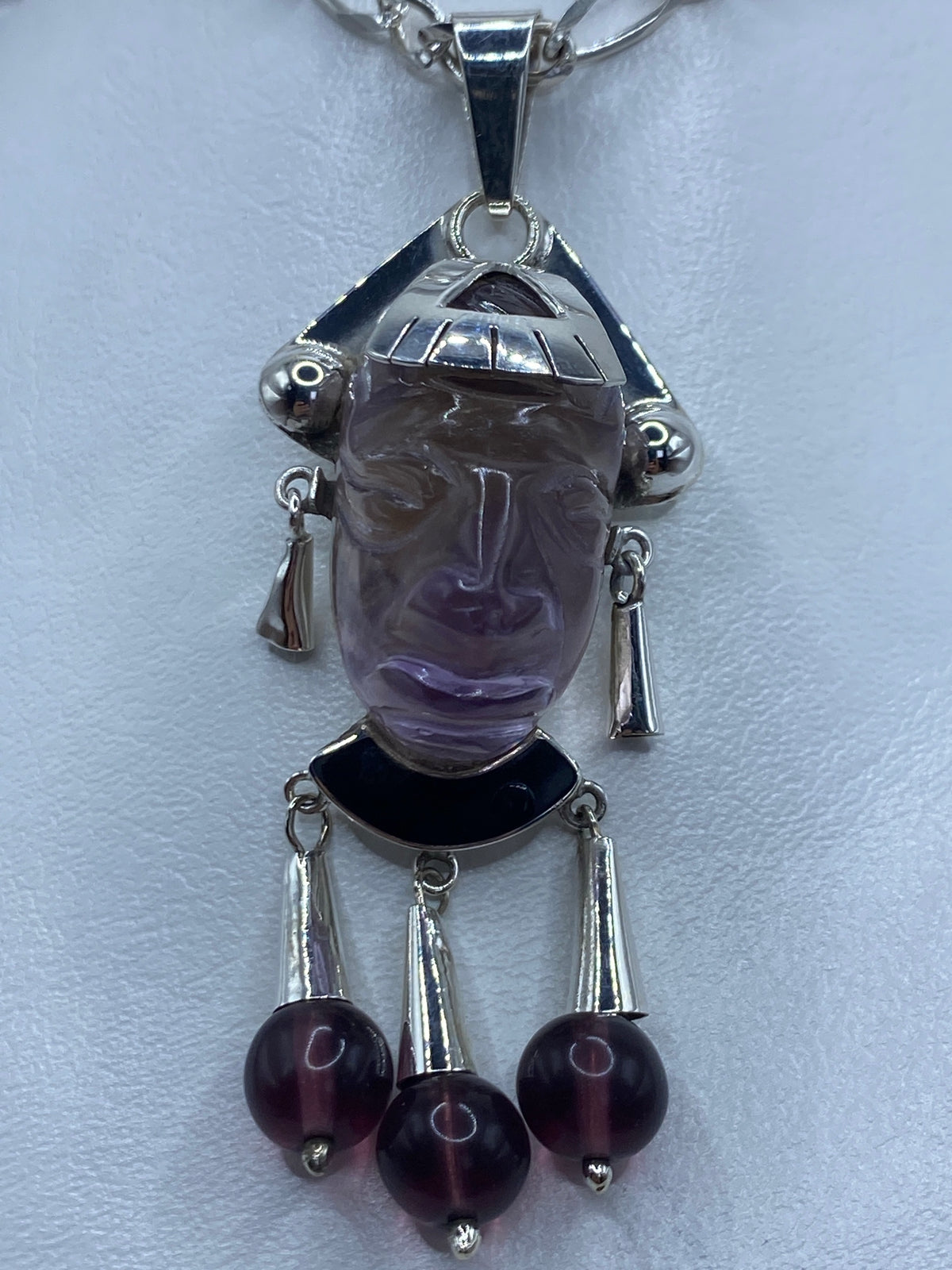 Detalle de amatista morada y ónix negro engastados en la parte inferior del dije