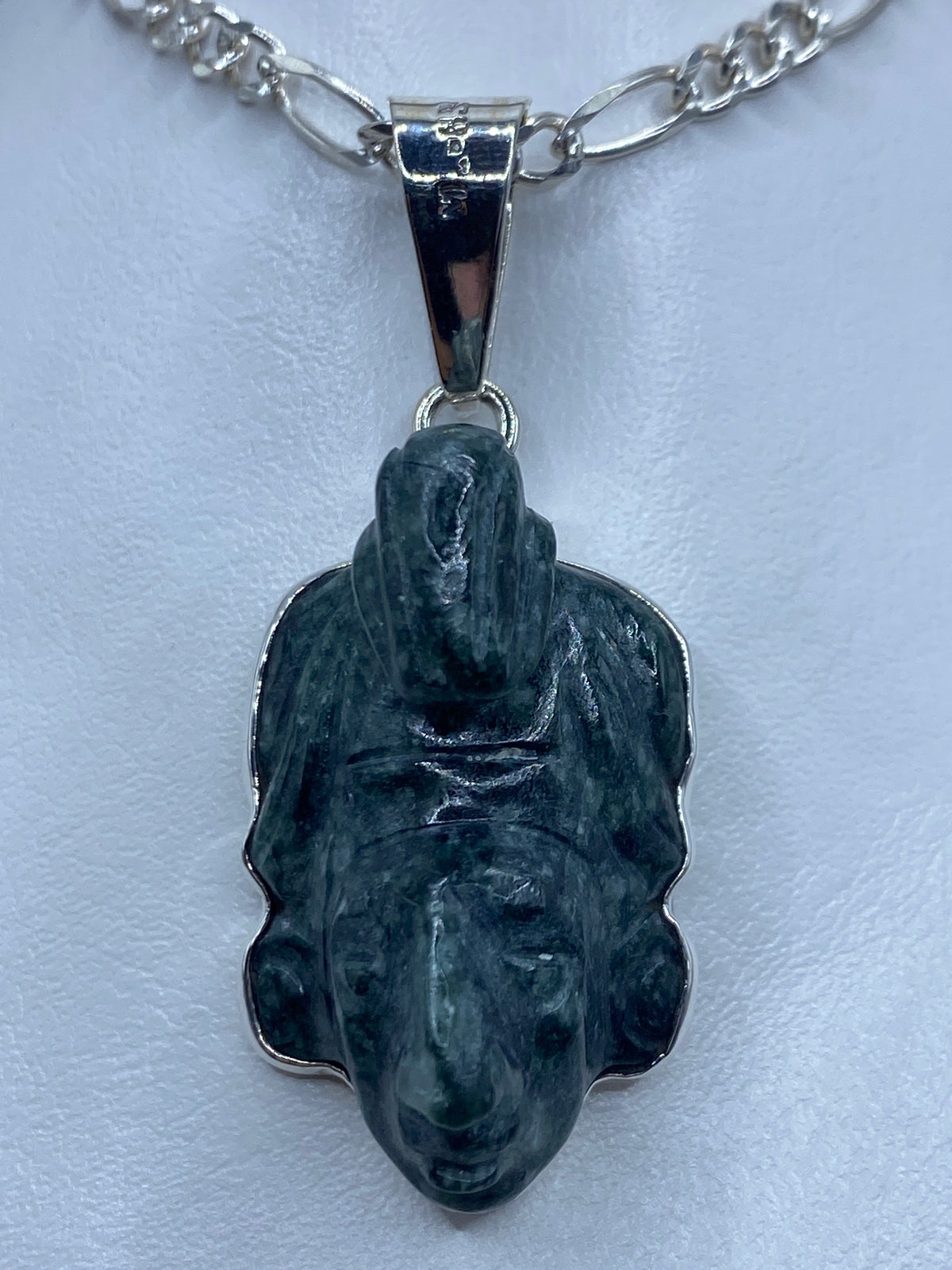 Vista frontal del dije prehispánico de 6.1 cm, mostrando los detalles del repujado y la corona