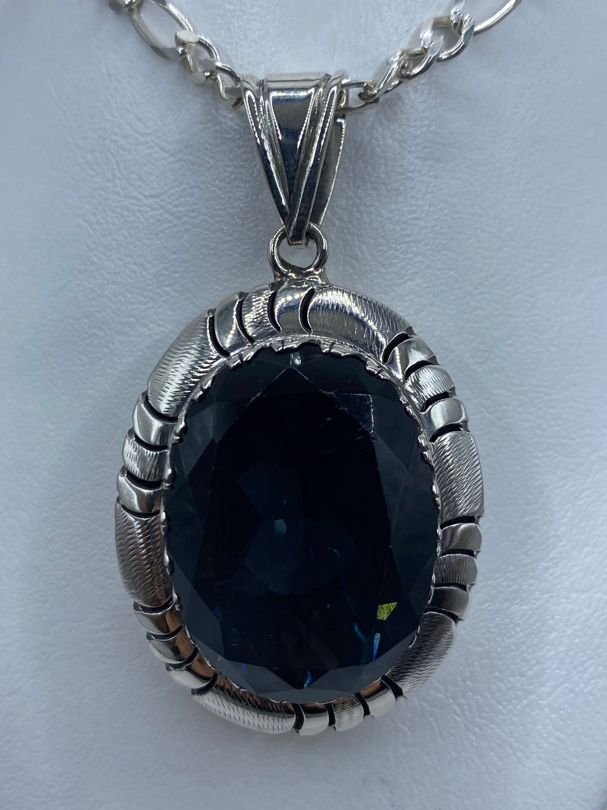 Detalle frontal: piedra facetada transparente en engaste de plata de Taxco