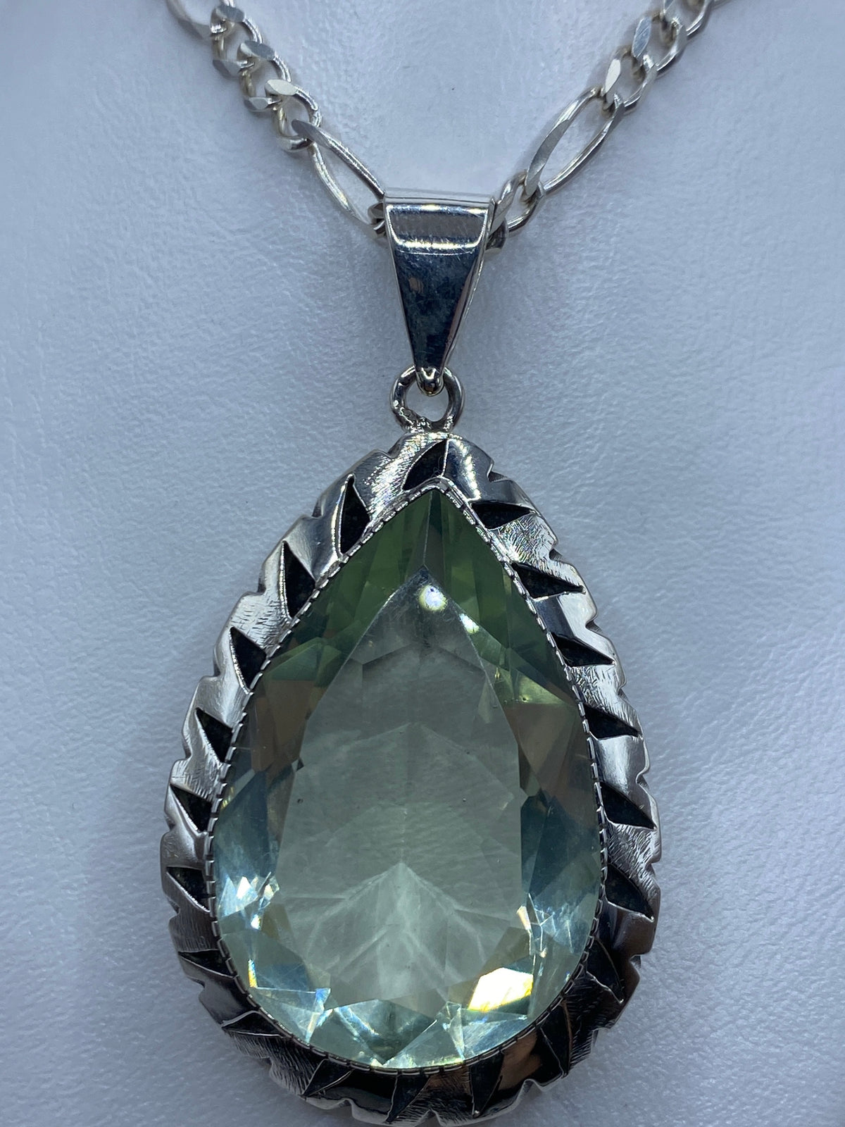 Dije de plata gota con circonia facetada colgando de cadena de plata brillo