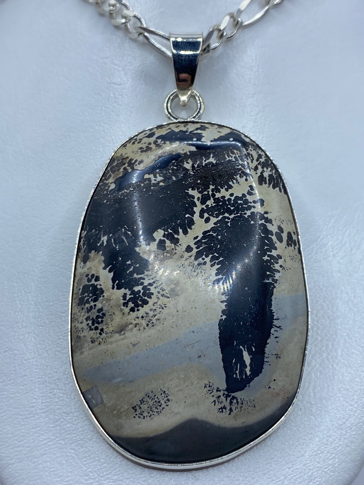 Vista frontal del dije mostrando la piedra natural y el acabado pulido de la plata 925