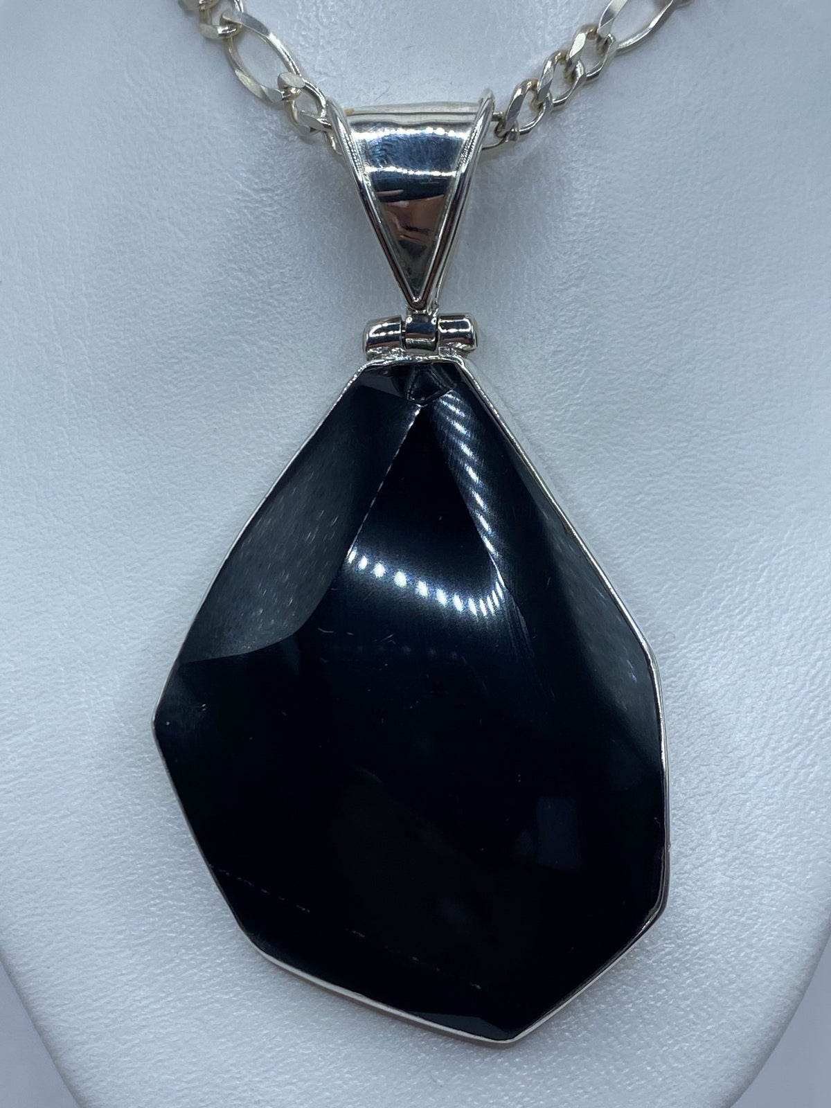 Dije de ónix negro en plata 925 con engaste plateado, visto de frente