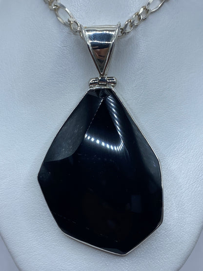 Dije de ónix negro en plata 925 con engaste plateado, visto de frente