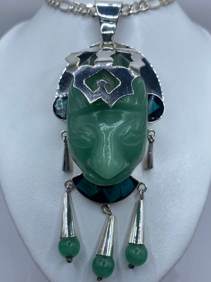 Dije de jade y malaquita en verde sobre cadena de plata, luciendo en el cuello