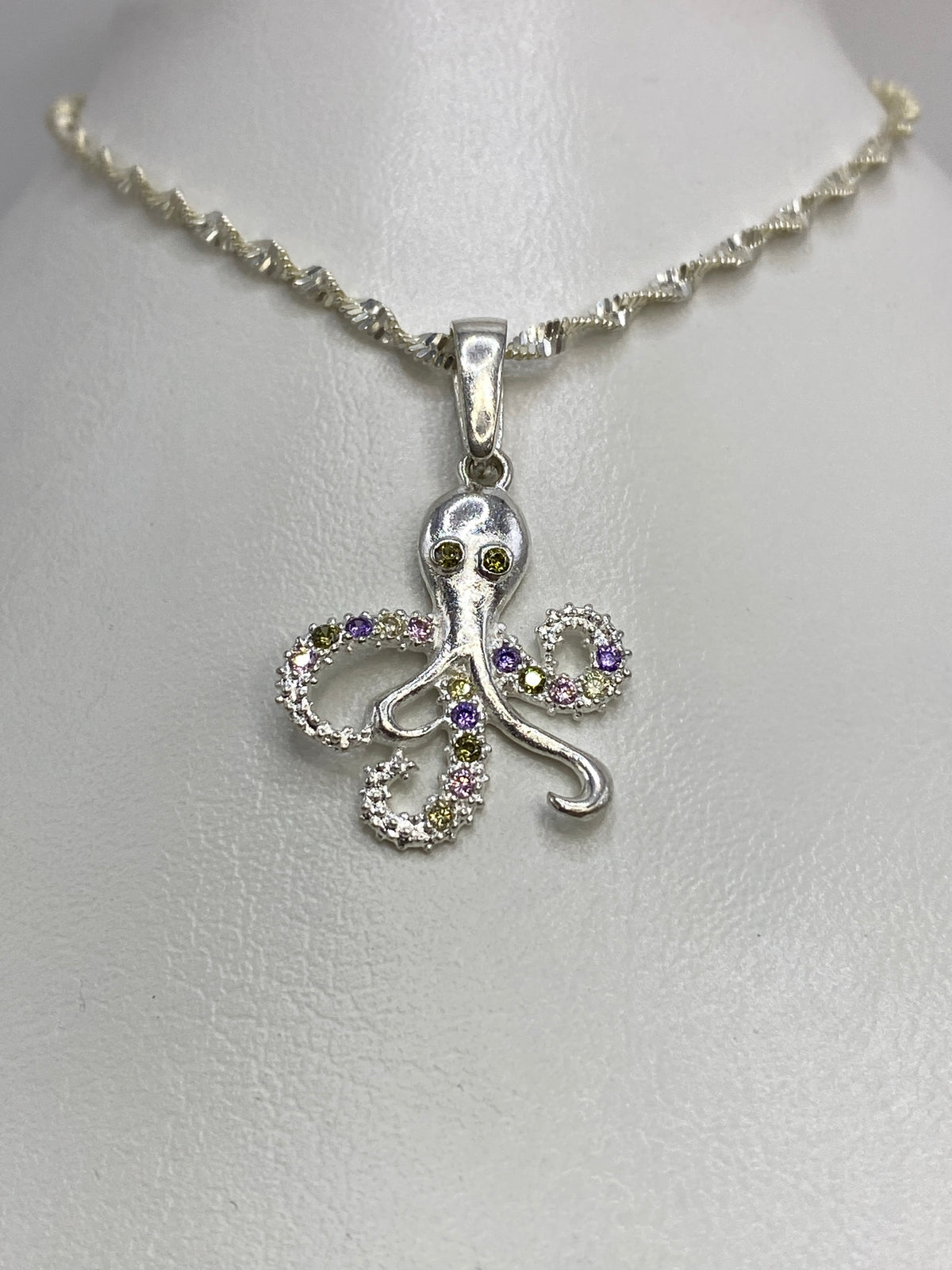Detalle del pulpo de plata mostrando el patrón de micro-engaste en purpura, amarillo verdoso e incoloro