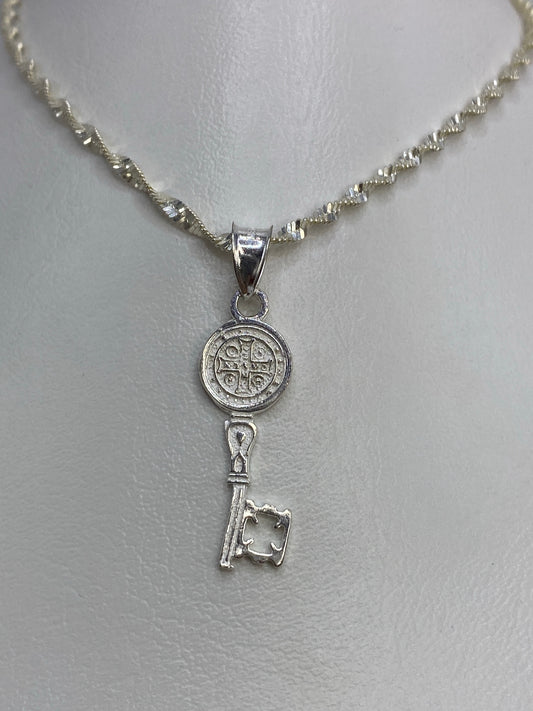Detalle frontal de la Medal de San Benito con diseño religioso fundido