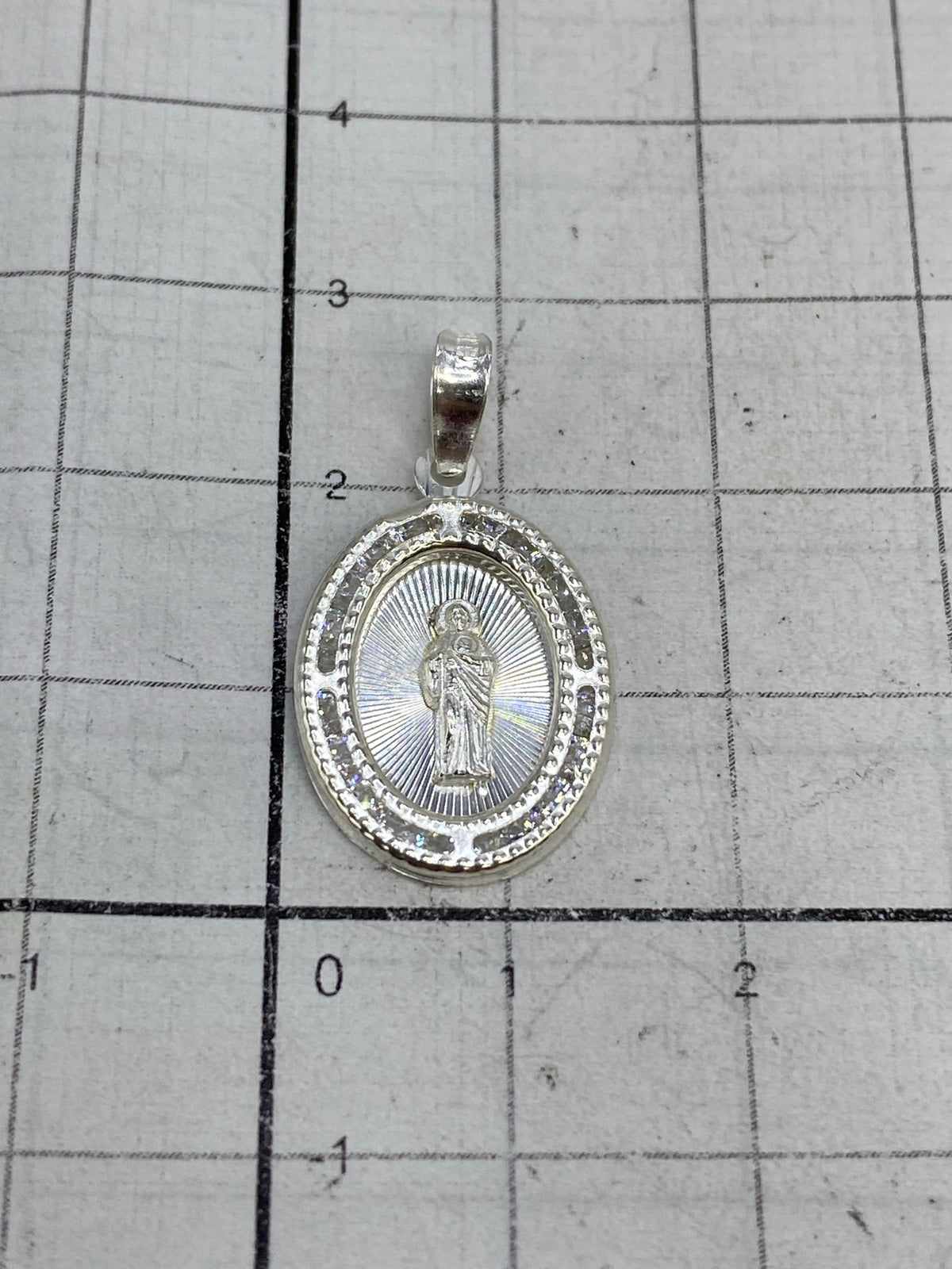 Dije de San Judas en báscula de precisión mostrando peso de 1.15 gramos