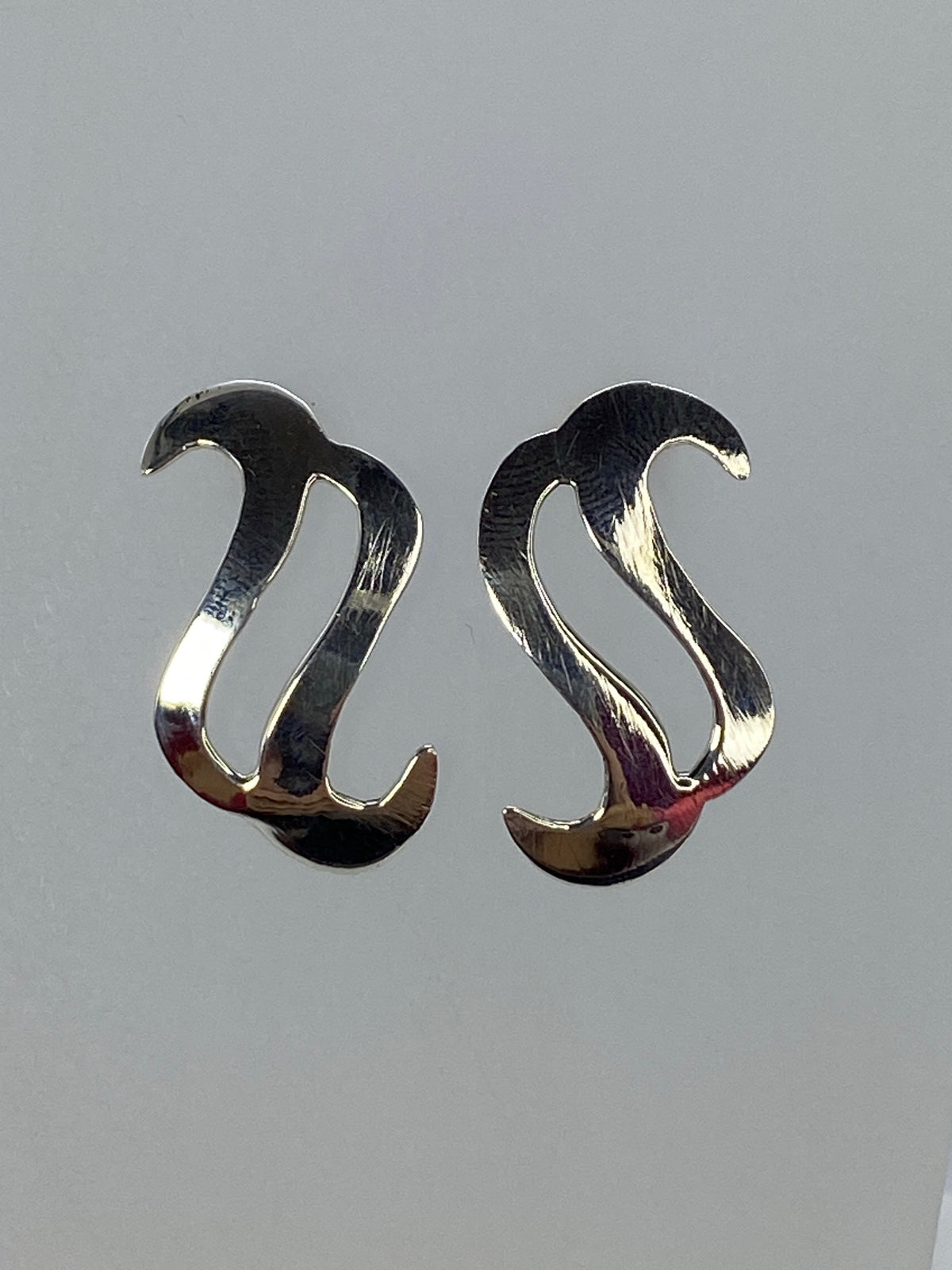 Par de aretes de plata en calado minimalista, visto de frente