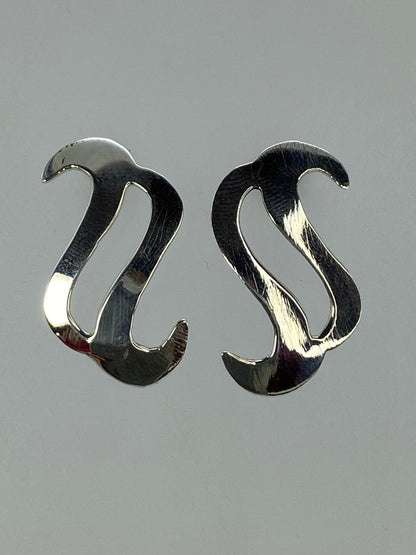Aretes de plata 925 sobre superficie neutra mostrando el Quinto