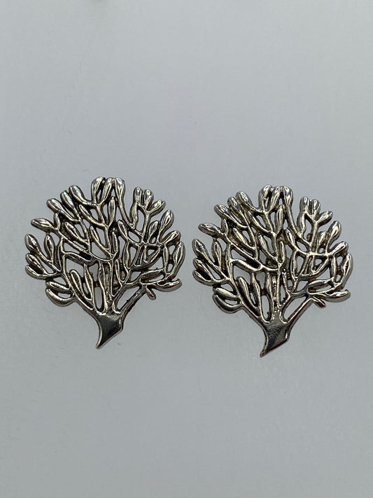 Par de aretes de plata en calado con diseño floral ramificado, sobre fondo gris