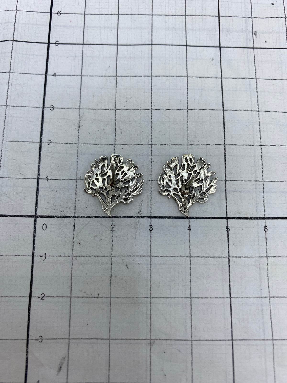 Aretes de plata 925 con Quinto, pesados en báscula de precisión mostrando 2.45 gramos