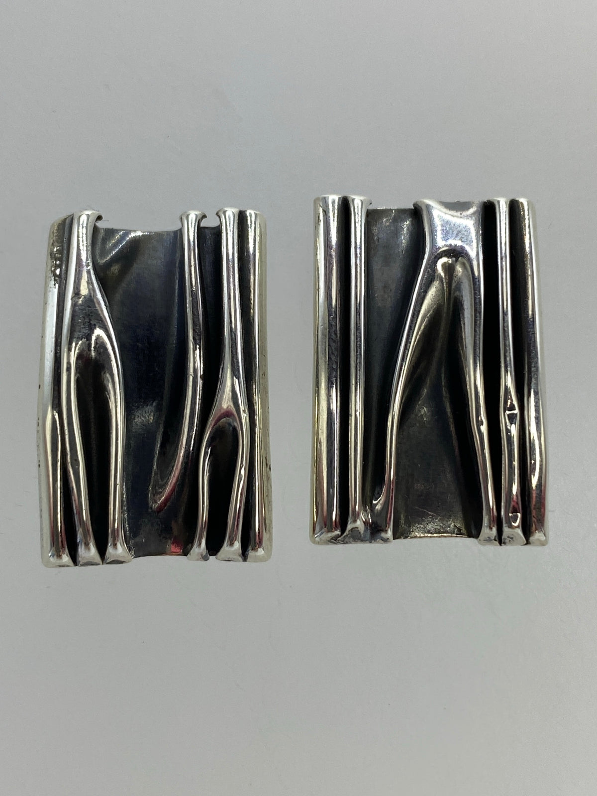 Par de aretes de plata geométricos de volumen, vista frontal