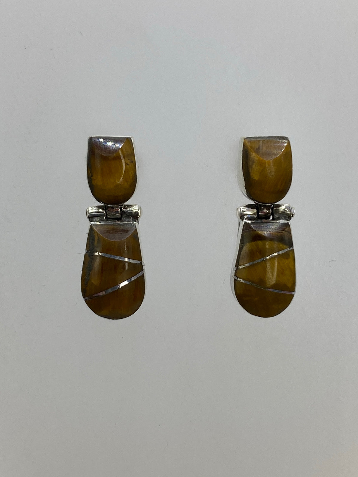 Aretes sobre fondo blanco, vista lateral mostrando el engaste a mano y el Quinto 950