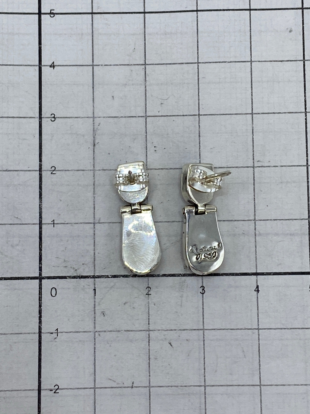 Aretes en la mano, 2 cm de largo, demostrando tamaño discreto y elegante