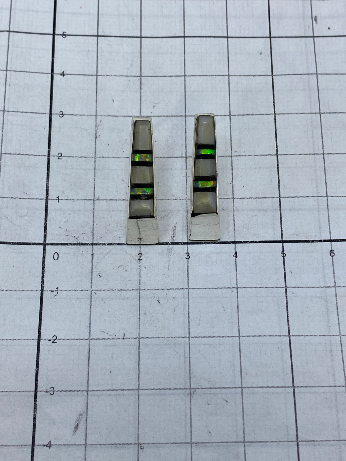 Aretes sobre fondo azul mostrando el Quinto 950 grabado en la base