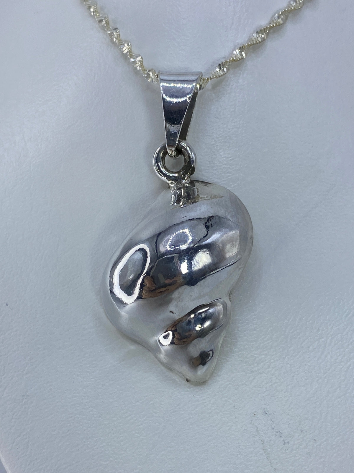 Dije de caracol de plata 925 fundido en Taxco, colgado de cadena plateada