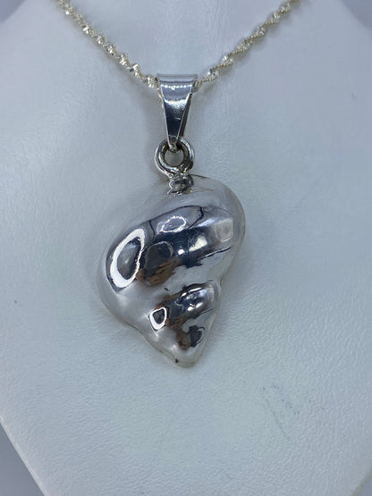 Detalle del caracol mostrando espiral y precisión del vaciado en plata