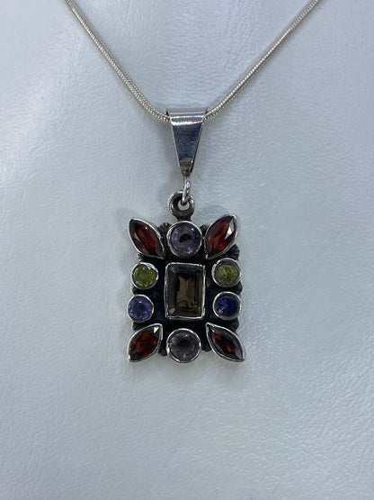 Dije de plata con circonia multicolor en marco geométrico colgando de cadena de plata