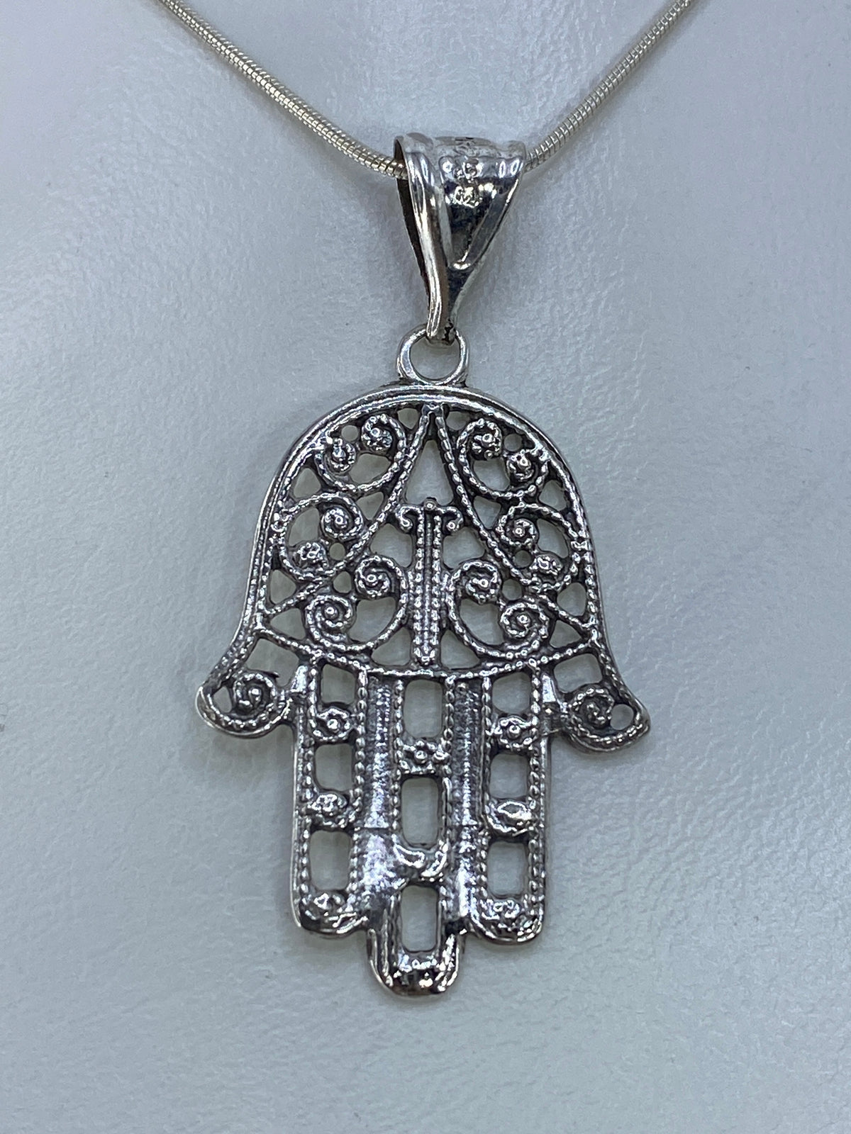 Dije mano de Fátima sobre regla mostrando medidas de 4.5 × 2.4 cm