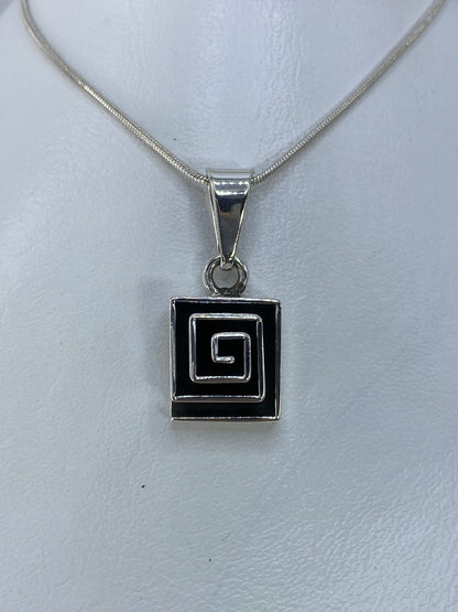 Dije de plata con espiral cuadrada concéntrica calada, colgando de cadena de eslabones