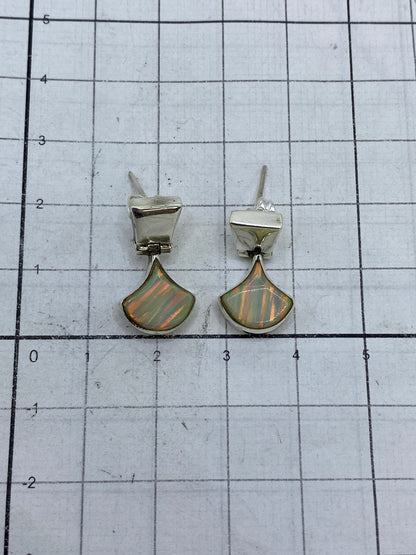 Aretes puestos mostrando el brillo multicolor del ópalo de fuego en Taxco 925