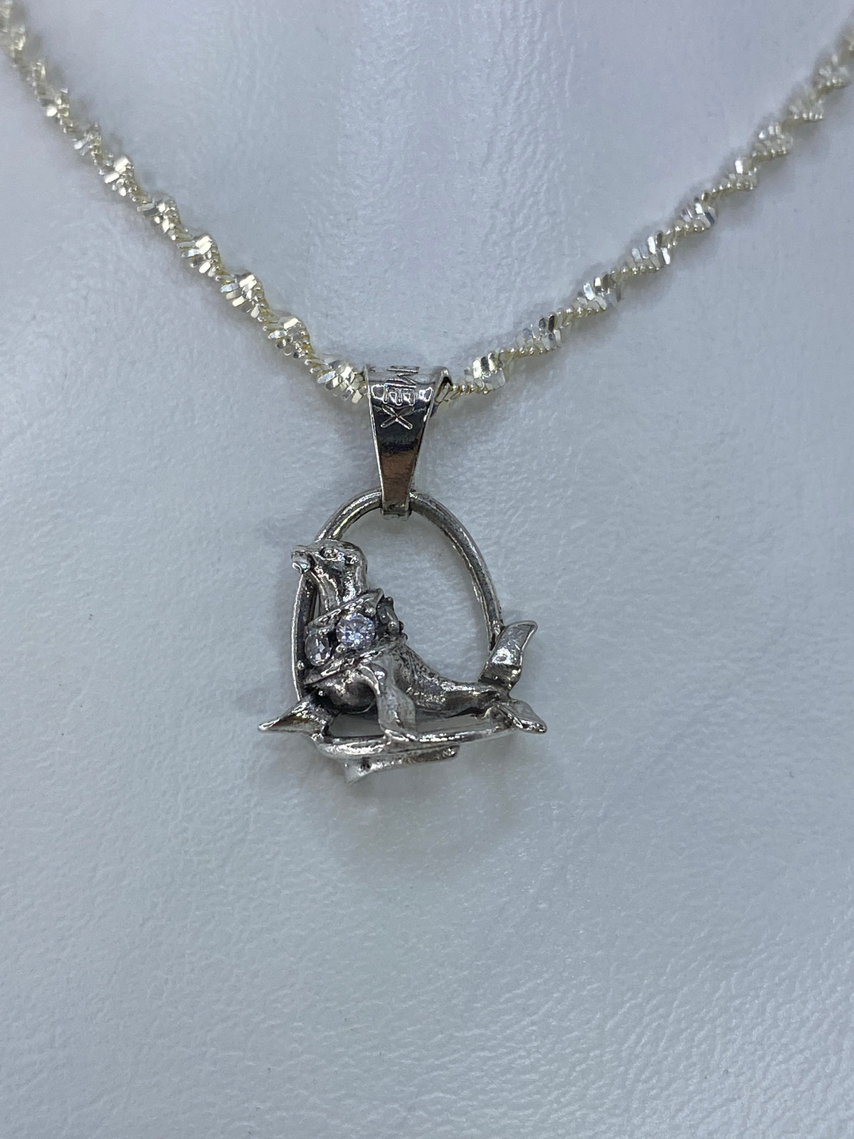 Dije foca de plata 925 con circonia en cadena plateada, vista frontal de cerca