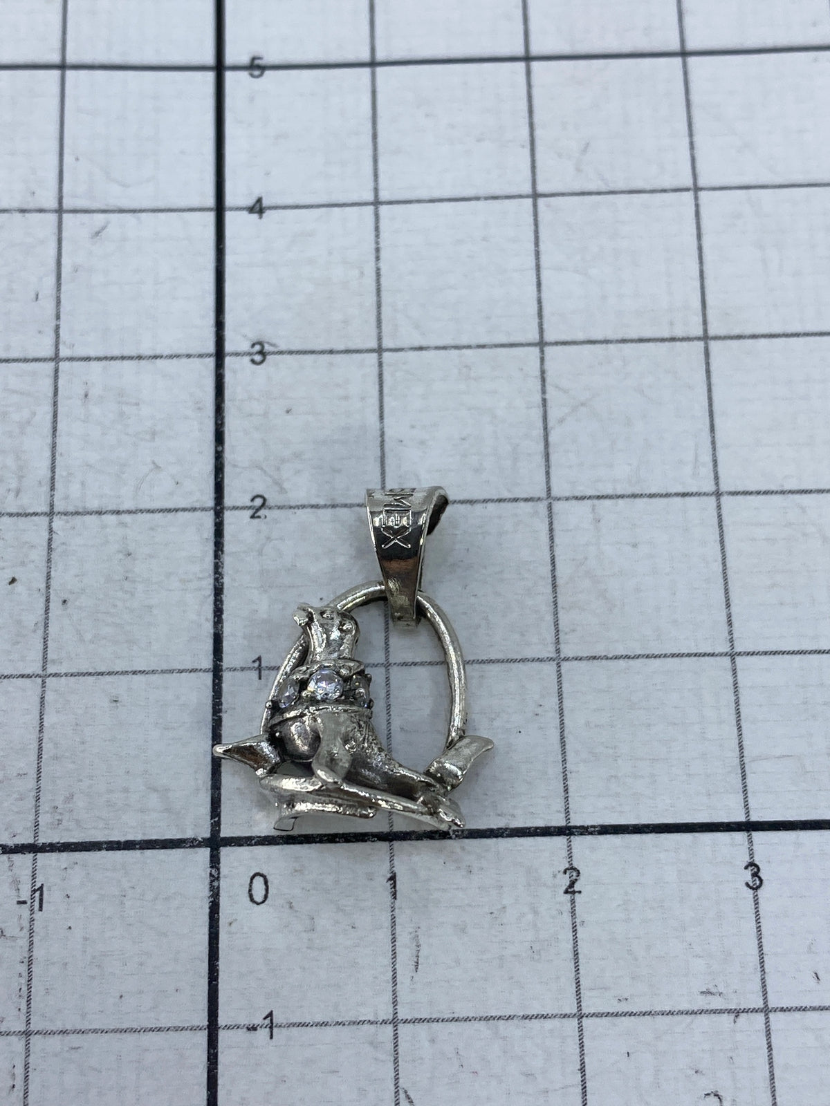 Dije foca de plata en la palma mostrando su tamaño miniatura