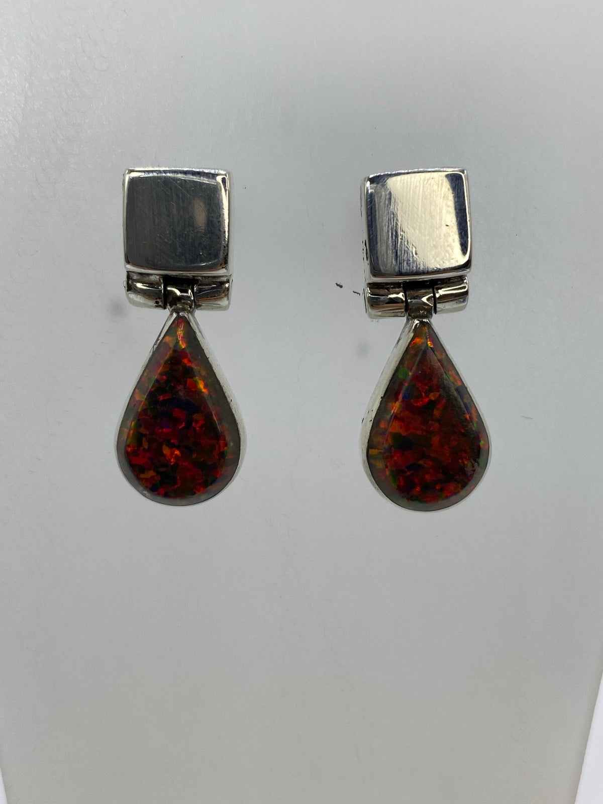 Aretes largos de 2.5 cm mostrando el brillo multicolor del ópalo engastado a mano