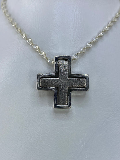 Detalle de la cruz de plata fundida, vista frontal con acabado satinado