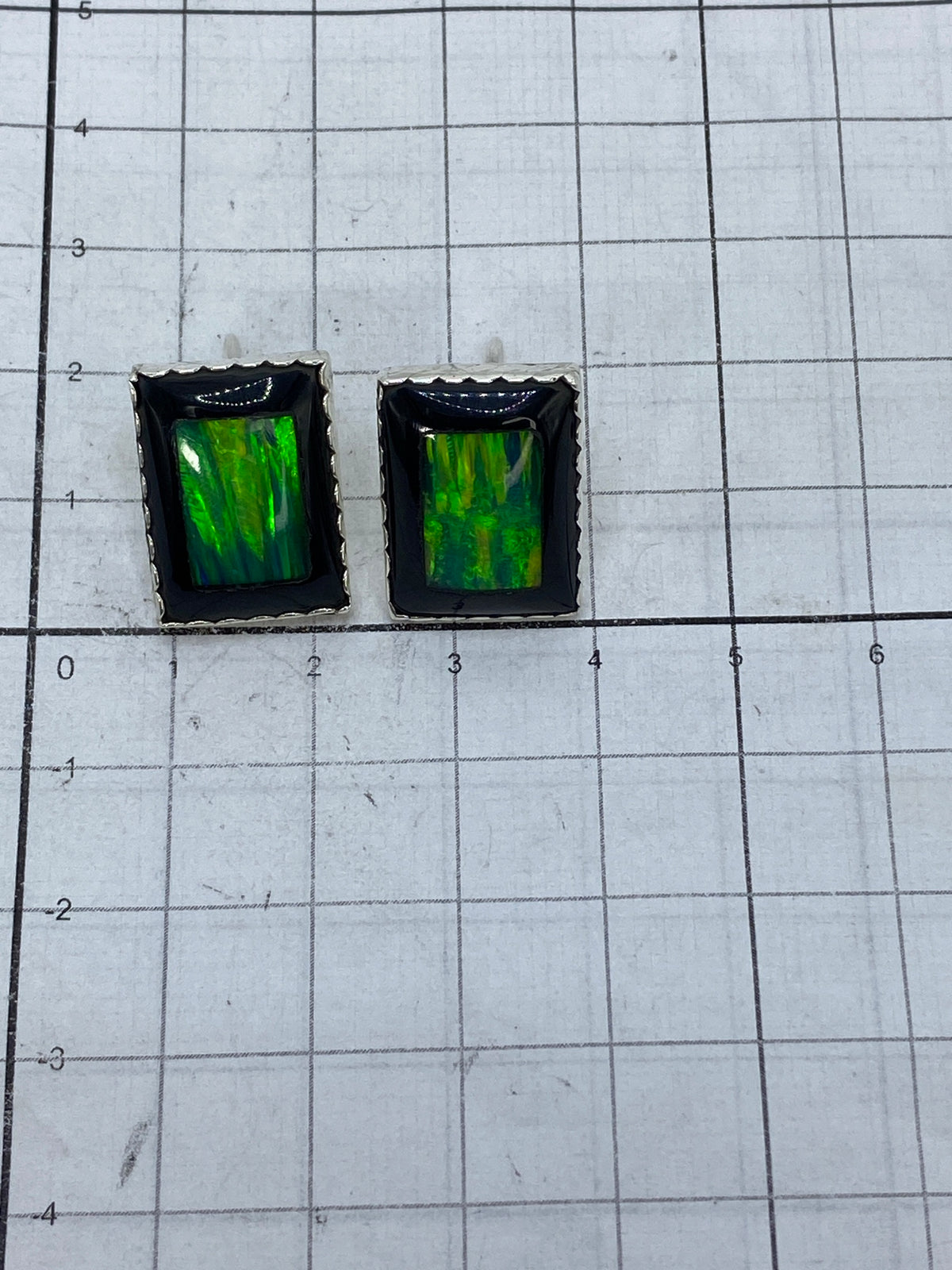 Reverso de los aretes mostrando el Quinto 950 y acabado pulido de la plata