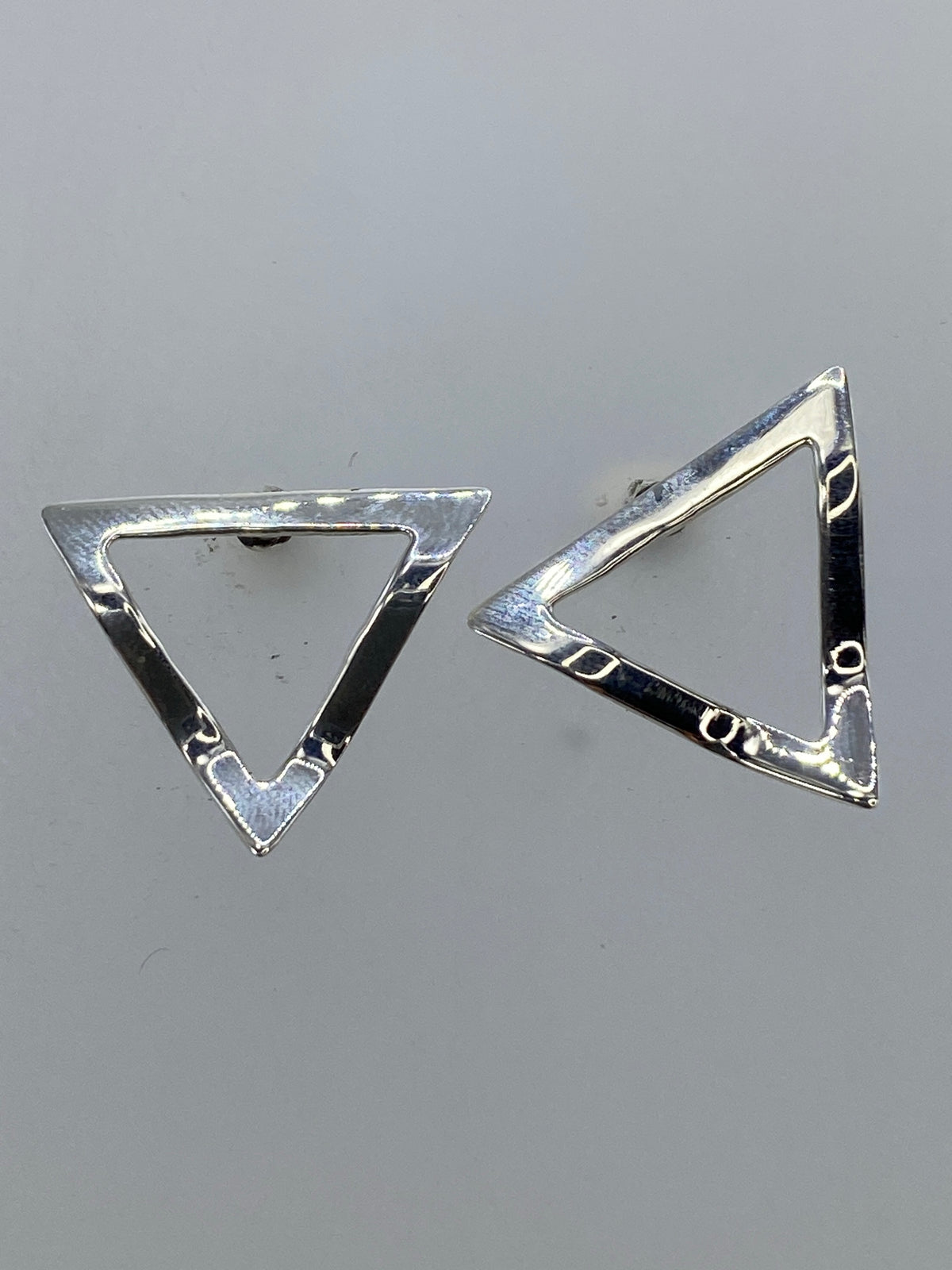 Par de aretes triangular en plata 925 con repujado artesanal de Taxco, vistos desde frente