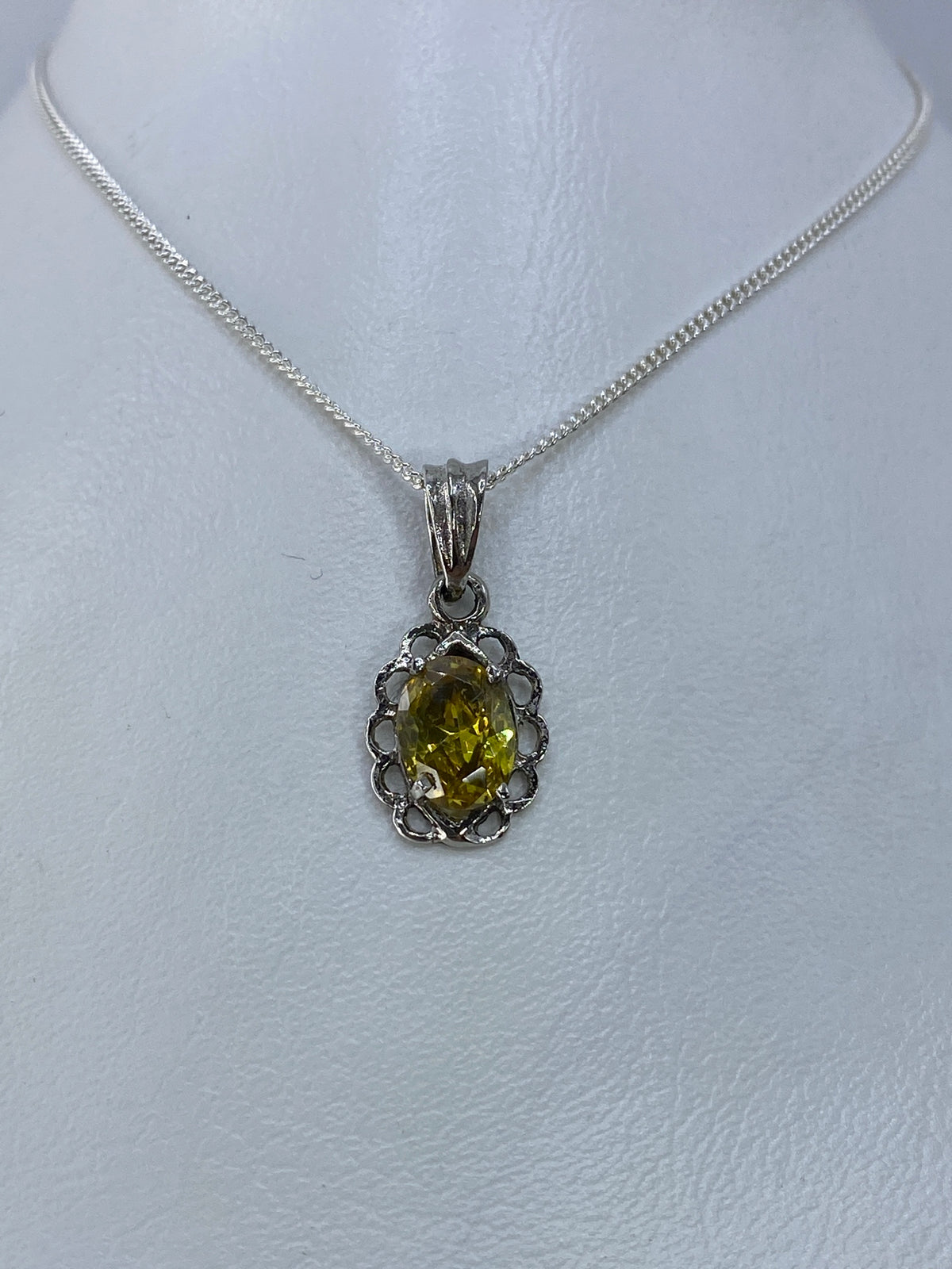 Detalle del dije mostrando la circonia amarillo engastada a mano en plata 925