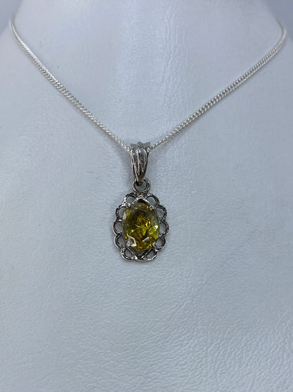 Detalle del dije mostrando la circonia amarillo engastada a mano en plata 925