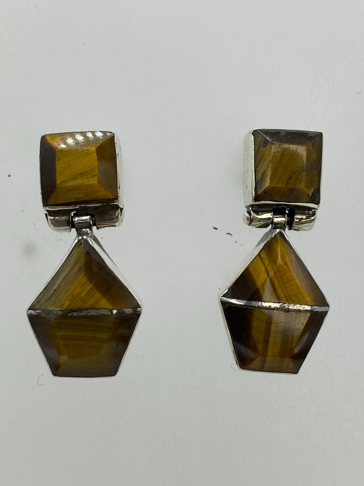 Pareja de aretes de plata con Ojo de Gato café, postes con mariposa, sobre fondo blanco