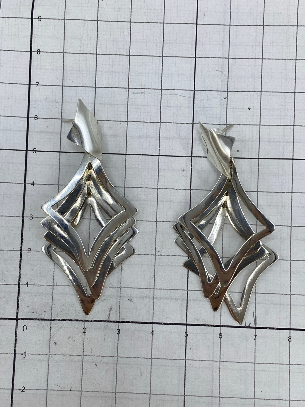 Aretes en báscula mostrando peso de 7.41 gramos el par