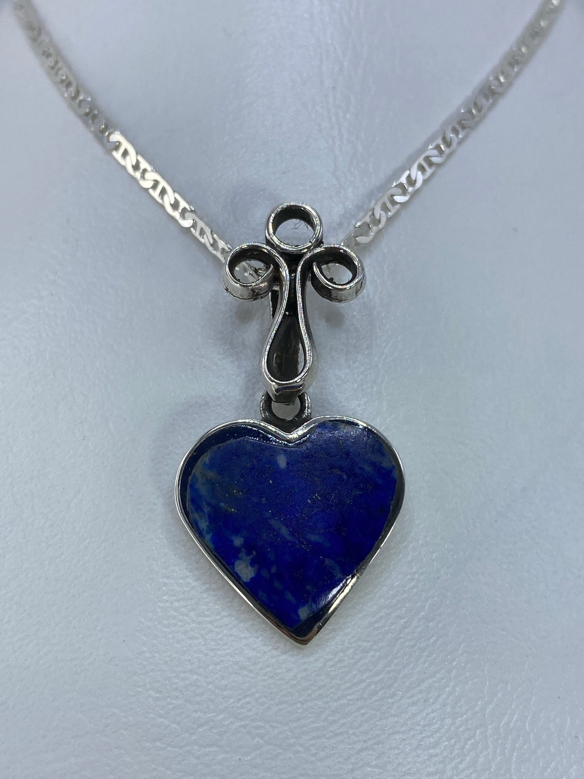 Detalle del engaste a mano de la piedra azul en el dije de plata