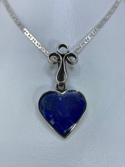 Detalle del engaste a mano de la piedra azul en el dije de plata