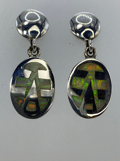 Par de aretes de plata 950 con ópalo de fuego multicolor engastado, vista frontal mostrando los colores verde y naranja de las piedras