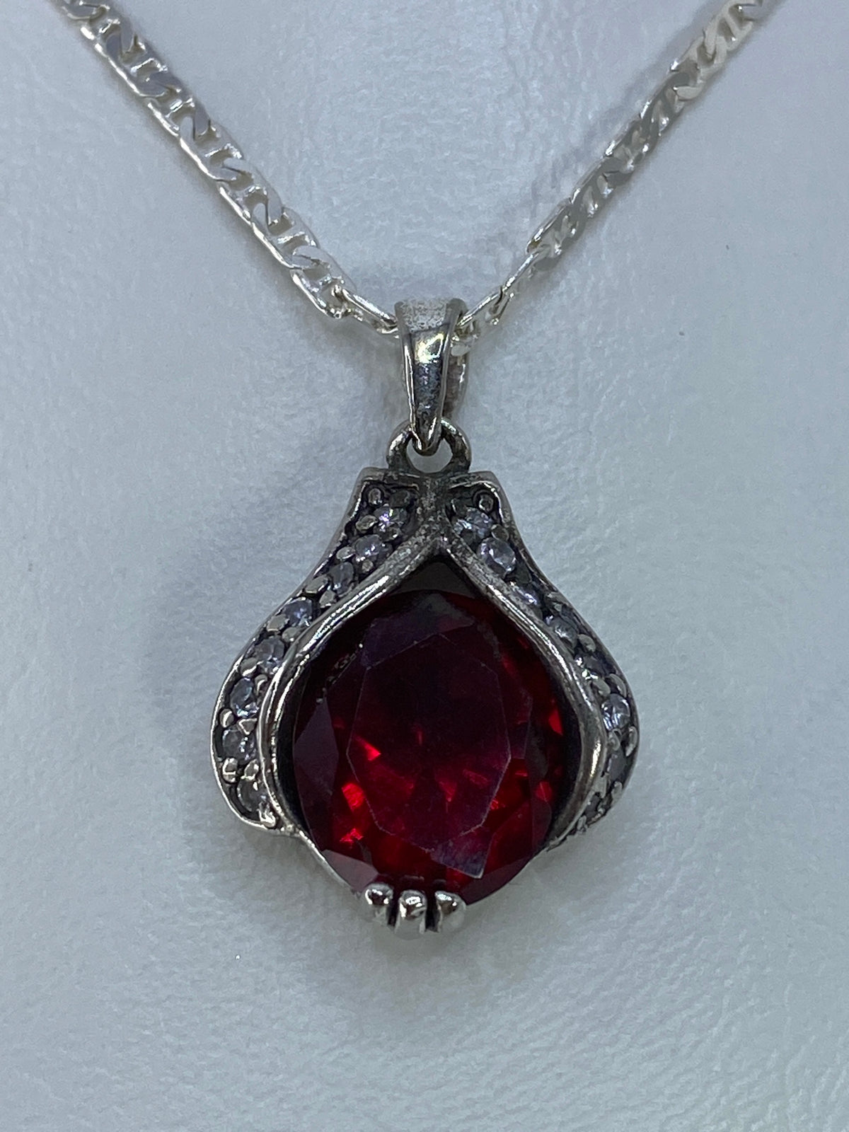 Dije de plata con circonia roja facetada, 2.2 cm, sobre cadena plateada