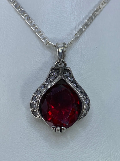 Dije de plata con circonia roja facetada, 2.2 cm, sobre cadena plateada