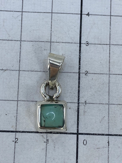 Dije de plata en balanza mostrando peso de 4.16 gramos