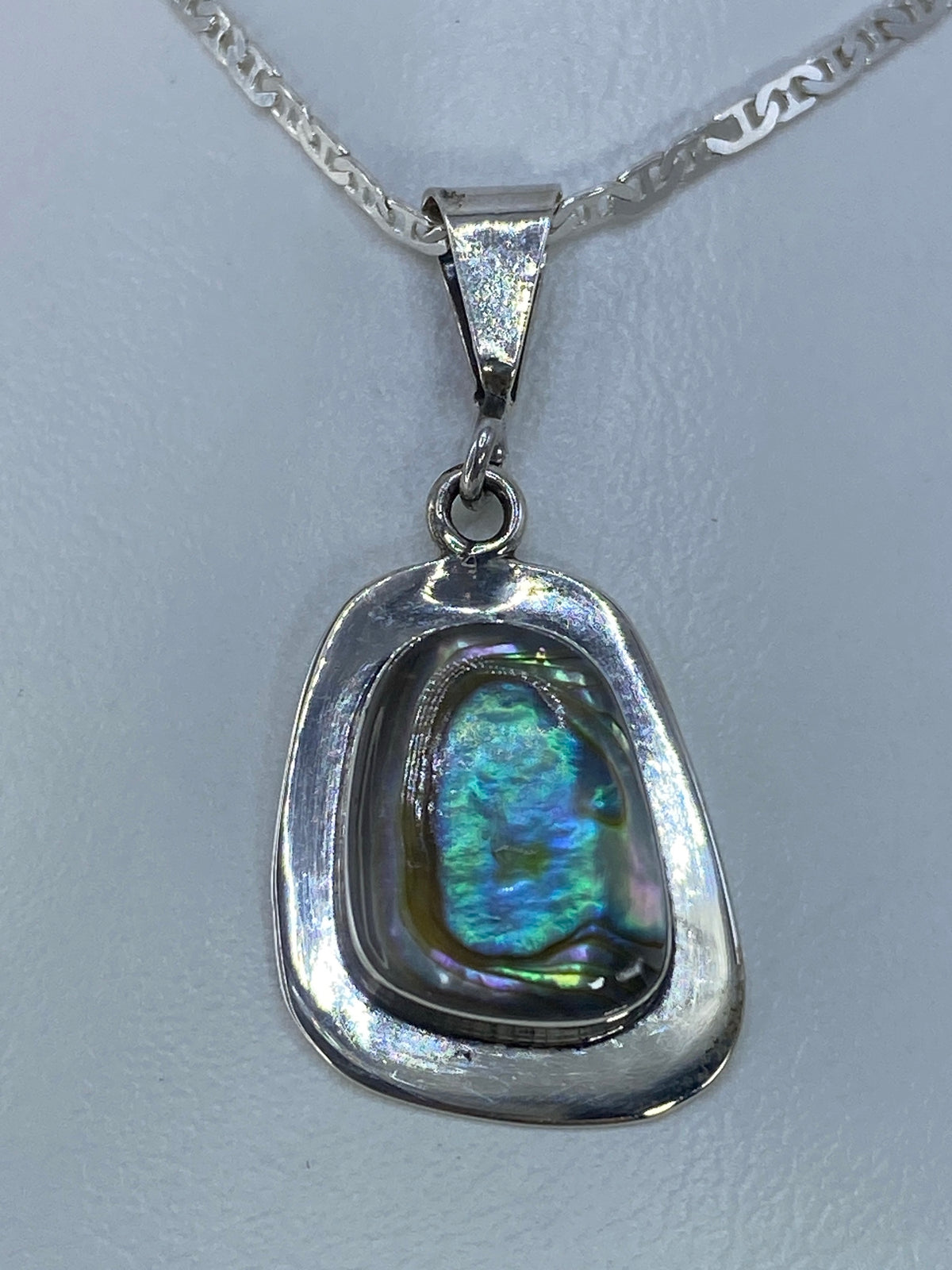 Dije de plata 925 con piedra natural multicolor iridiscente colgando de cadena plateada