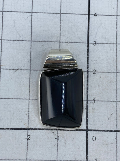 Dije sobre collar de plata para referencia de tamaño y proporción