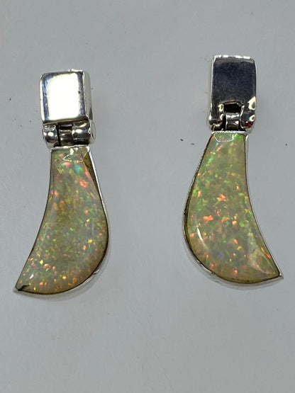 Aretes colgantes sobre fondo blanco, visible el Quinto 925 en la base de plata