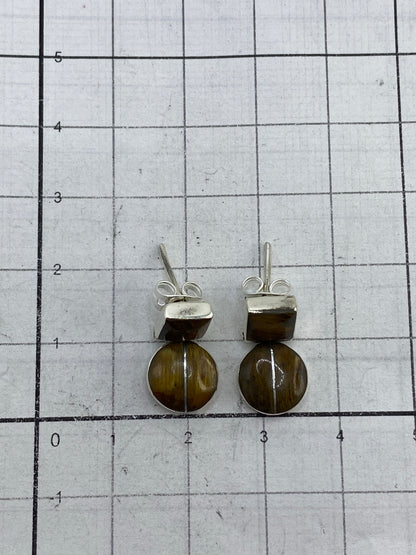 Aretes de Ojo de Tigre sobre fondo neutro mostrando el Quinto 950