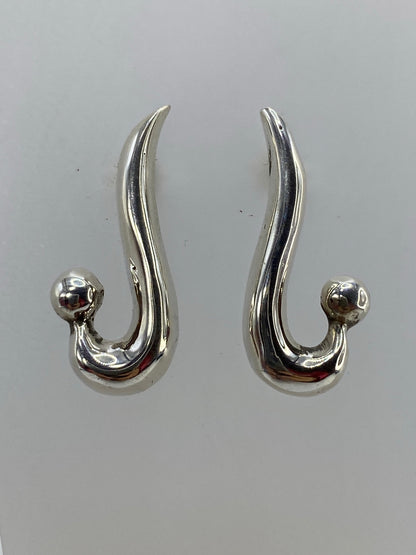 Detalle de los aretes cartoneado mostrando la técnica de lámina de plata y el acabado espejo