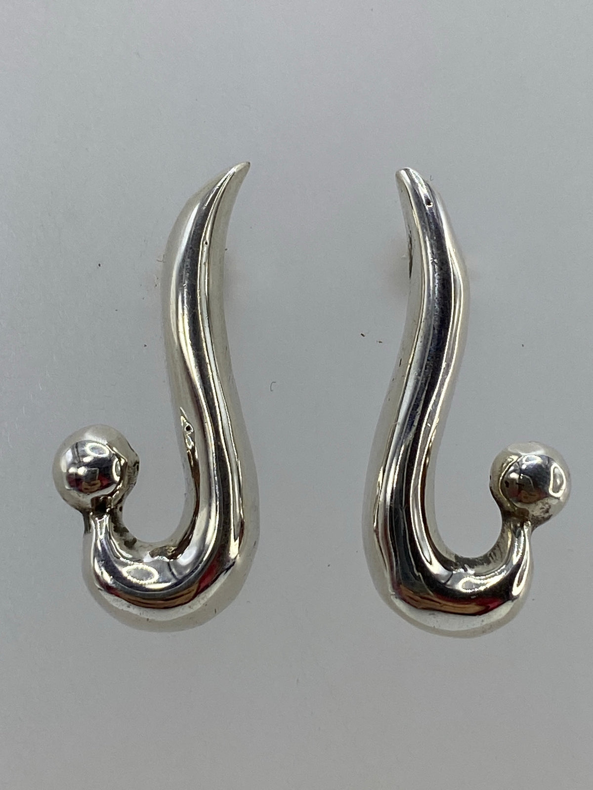 Aretes en la mano mostrando el peso ligero y la curvatura orgánica